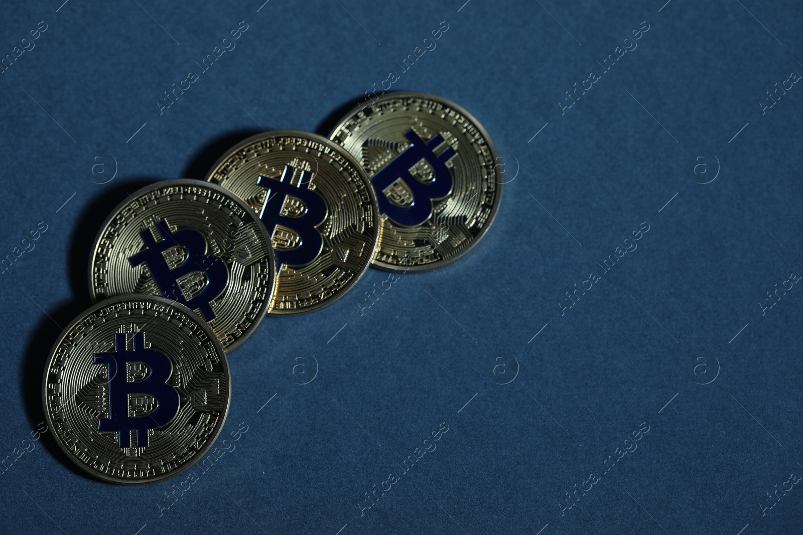 Cryptocurrency. Golden bitcoins on dark blue background, flat lay. Space for text Photo of Cryptocurrency. Golden bitcoins on dark blue background, flat lay. Space for text