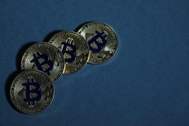 Photo of Cryptocurrency. Golden bitcoins on dark blue background, flat lay. Space for text