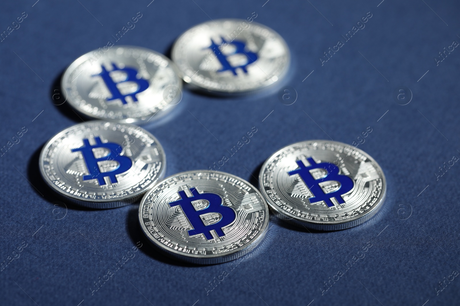 Cryptocurrency. Silver bitcoins on dark blue background, closeup Photo of Cryptocurrency. Silver bitcoins on dark blue background, closeup