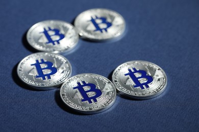 Photo of Cryptocurrency. Silver bitcoins on dark blue background, closeup