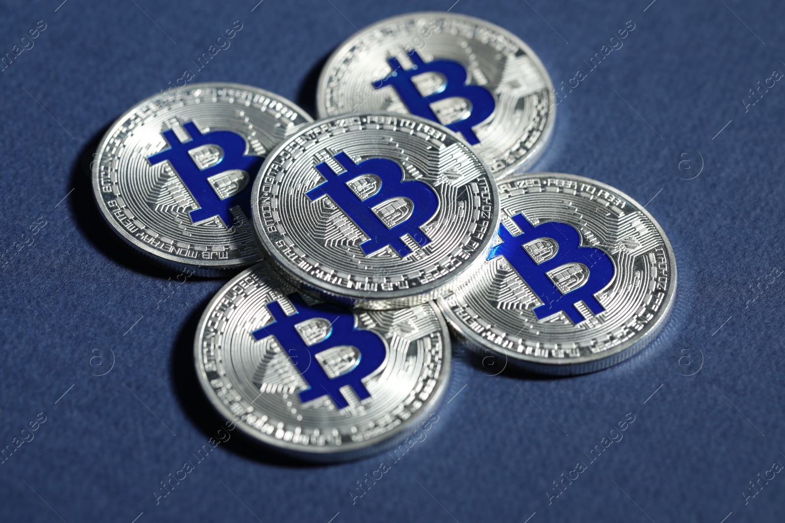 Cryptocurrency. Silver bitcoins on dark blue background, closeup Photo of Cryptocurrency. Silver bitcoins on dark blue background, closeup