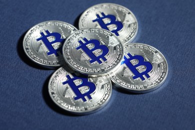 Photo of Cryptocurrency. Silver bitcoins on dark blue background, closeup
