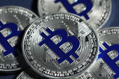 Photo of Cryptocurrency. Silver bitcoins on dark blue background, closeup