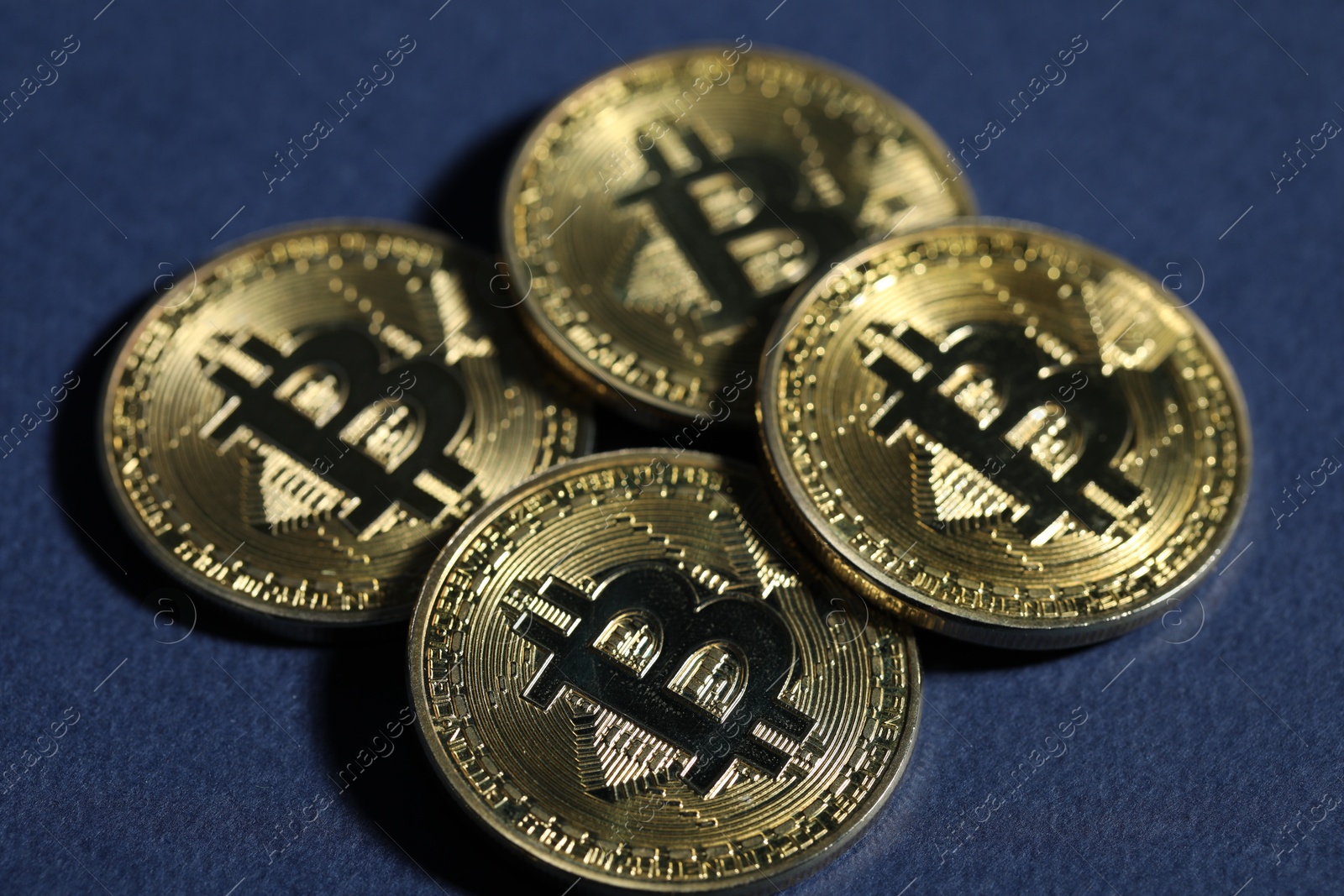 Cryptocurrency. Golden bitcoins on dark blue background, closeup Photo of Cryptocurrency. Golden bitcoins on dark blue background, closeup
