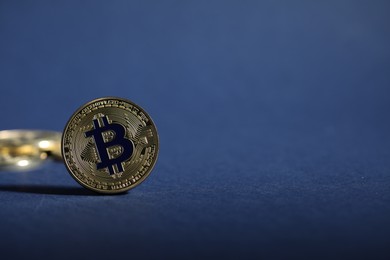 Photo of Cryptocurrency. Golden bitcoins on dark blue background, closeup. Space for text