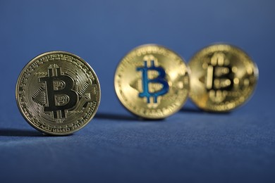 Photo of Cryptocurrency. Golden bitcoins on dark blue background, closeup