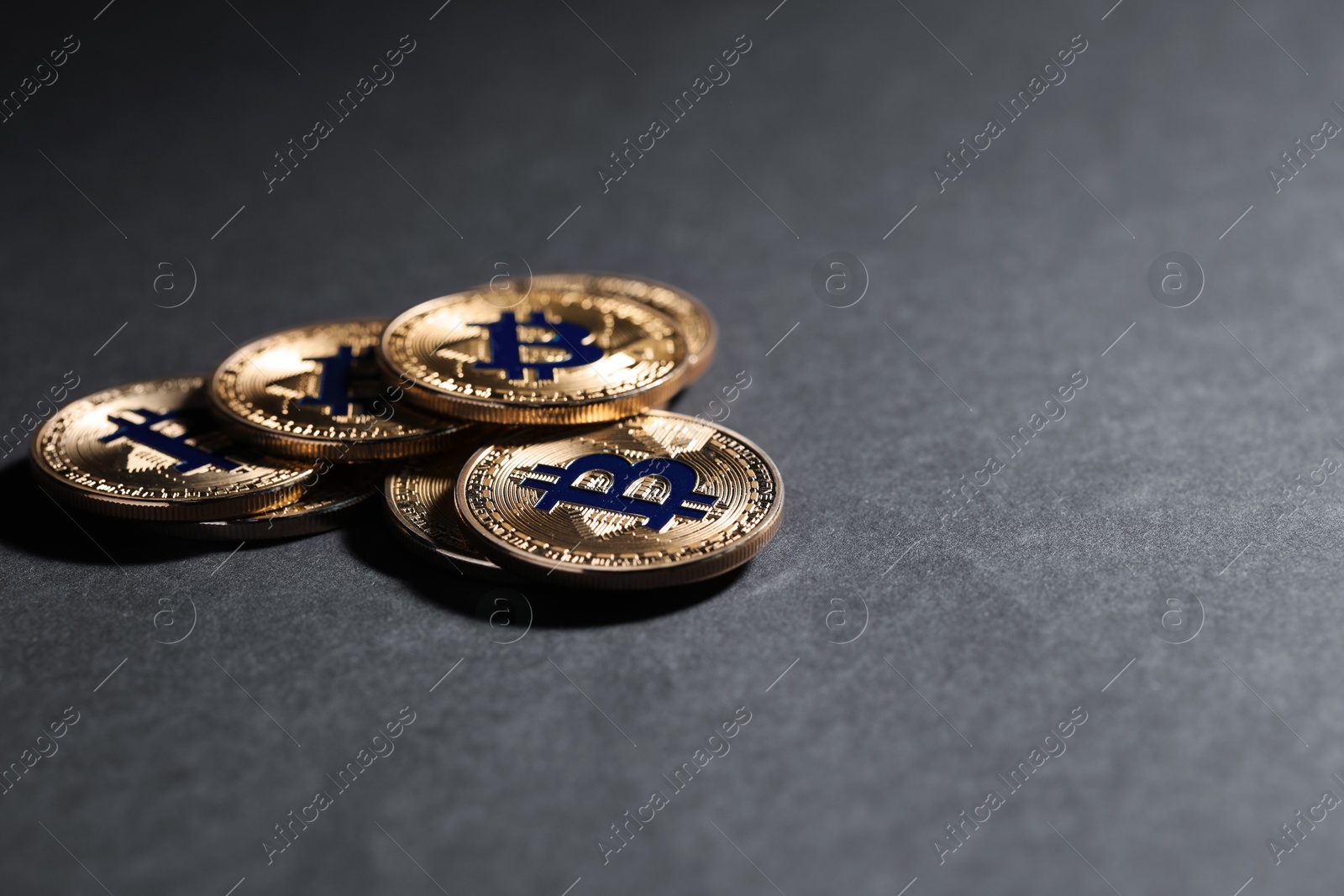 Cryptocurrency. Golden bitcoins on grey background, closeup. Space for text Photo of Cryptocurrency. Golden bitcoins on grey background, closeup. Space for text