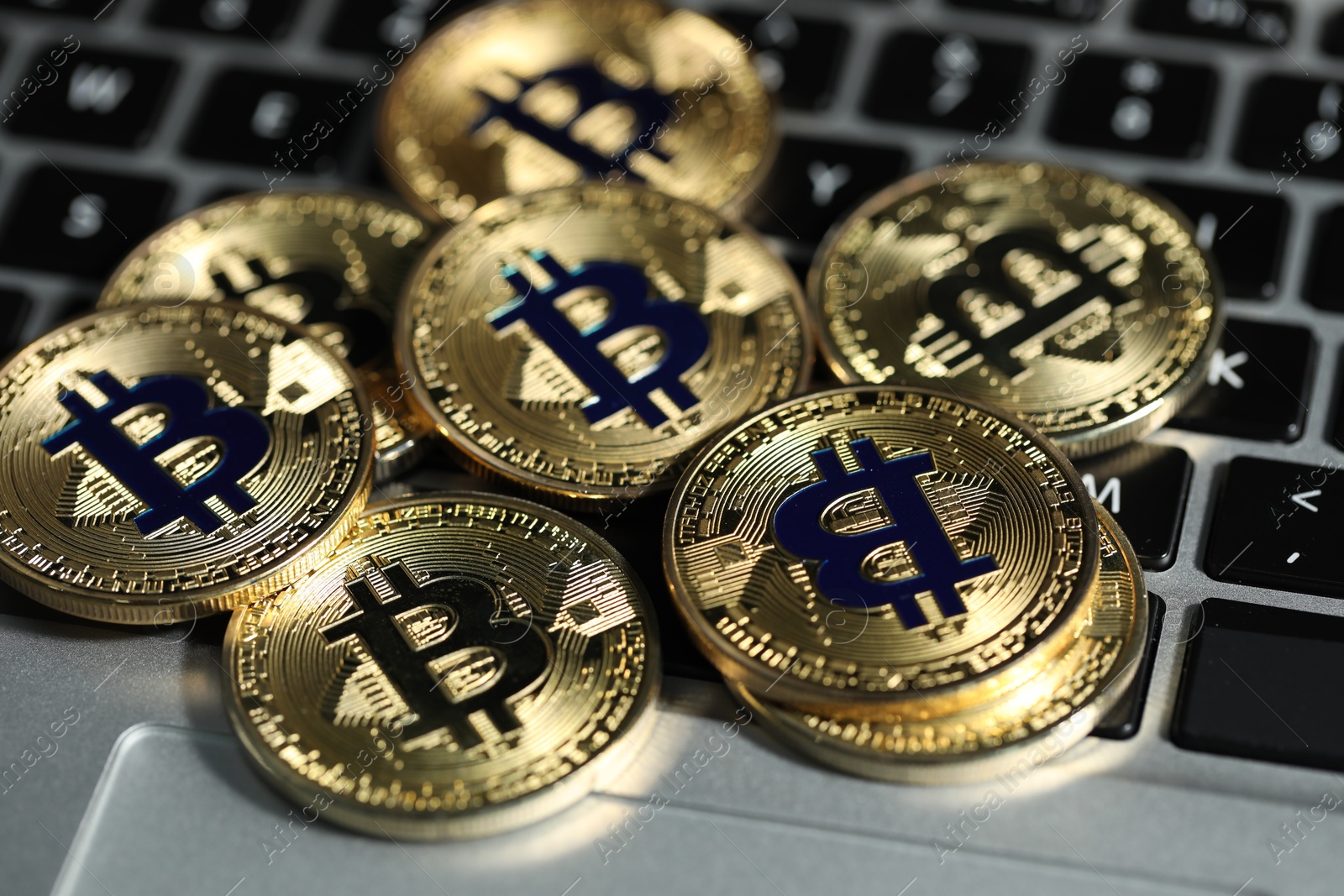 Cryptocurrency. Golden bitcoins on laptop, closeup view Photo of Cryptocurrency. Golden bitcoins on laptop, closeup view
