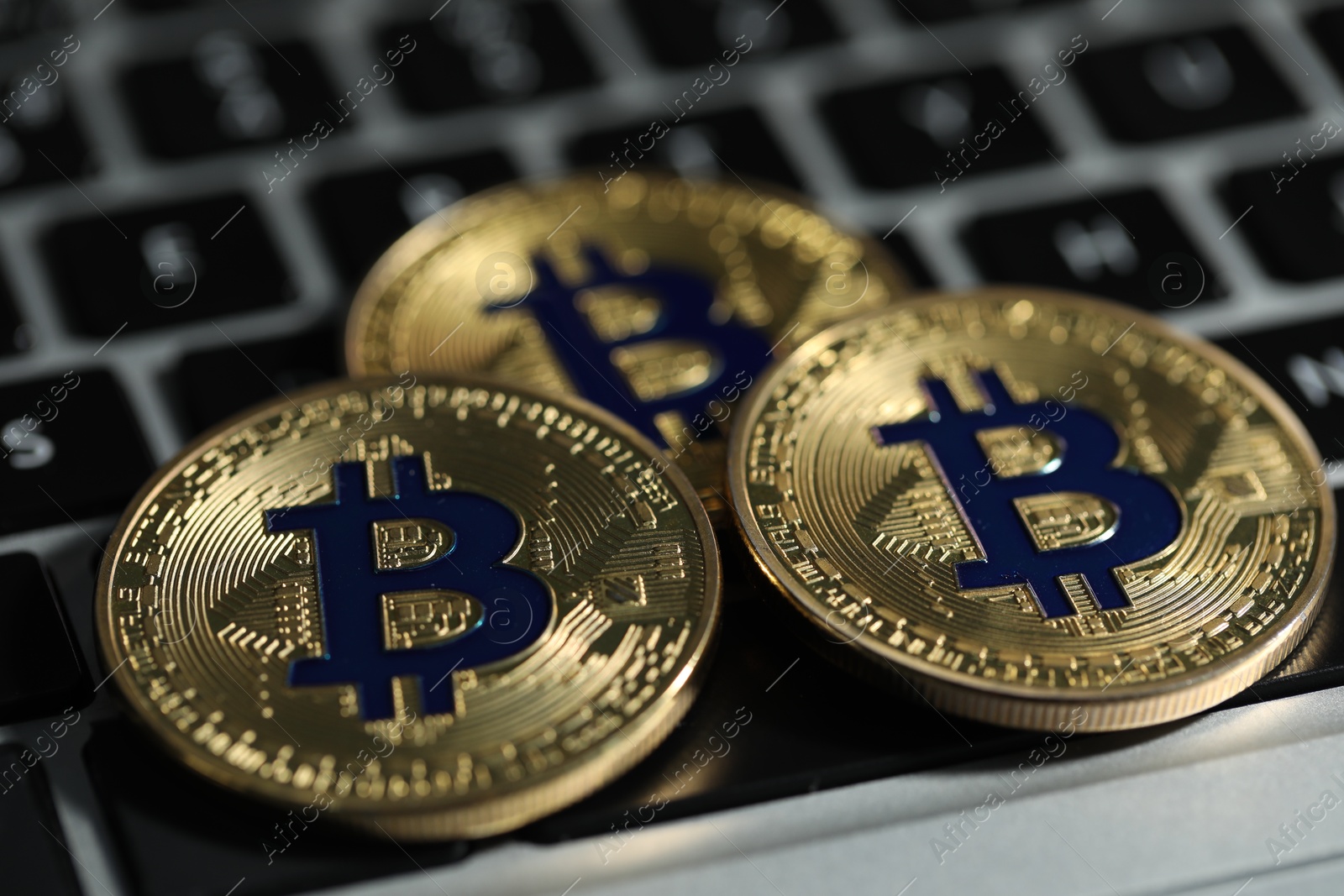 Cryptocurrency. Golden bitcoins on laptop, closeup view Photo of Cryptocurrency. Golden bitcoins on laptop, closeup view