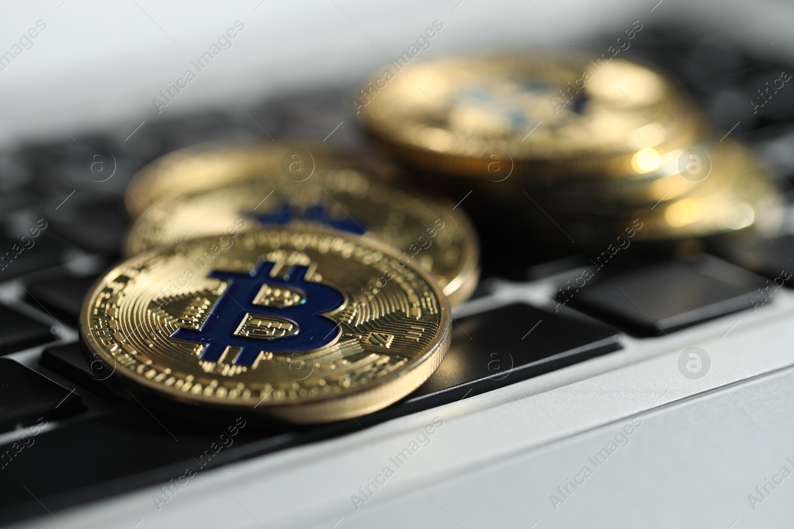 Cryptocurrency. Golden bitcoins on laptop, closeup view Photo of Cryptocurrency. Golden bitcoins on laptop, closeup view