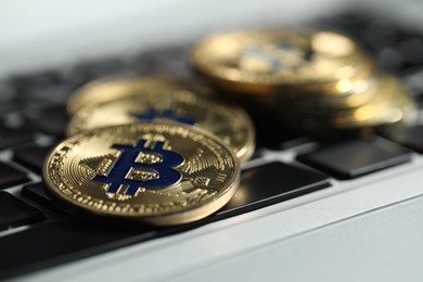 Photo of Cryptocurrency. Golden bitcoins on laptop, closeup view