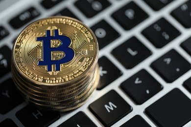Photo of Cryptocurrency. Golden bitcoins on laptop, closeup. Space for text