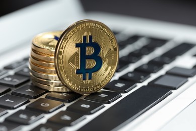 Photo of Cryptocurrency. Golden bitcoins on laptop, closeup view