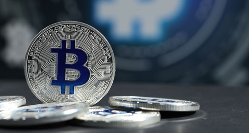 Photo of Cryptocurrency. Silver bitcoins on grey table, closeup. Space for text