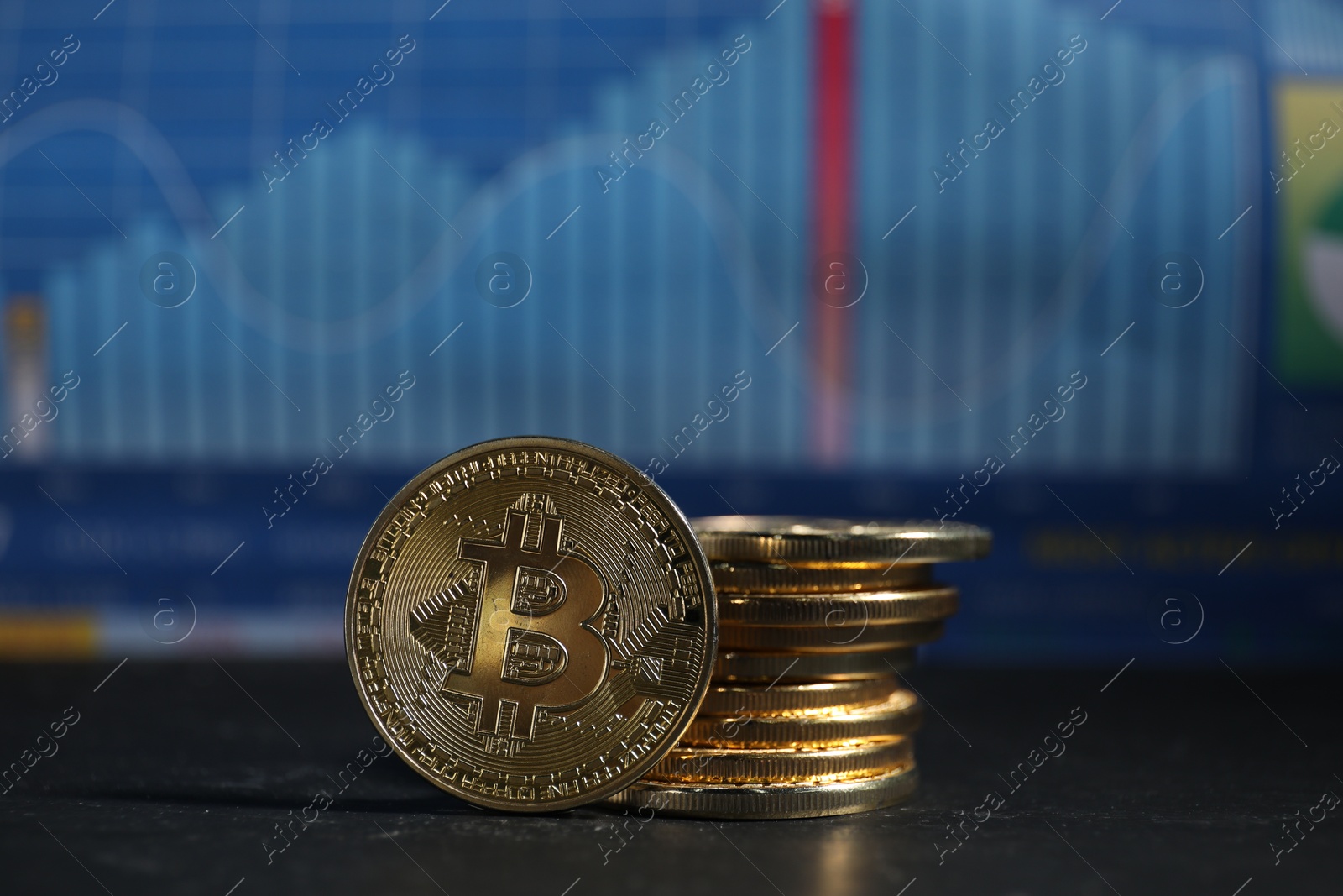 Cryptocurrency. Bitcoins on black table against data charts, closeup Photo of Cryptocurrency. Bitcoins on black table against data charts, closeup