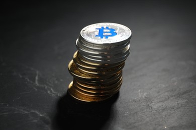 Photo of Cryptocurrency. Stack of bitcoins on black table, closeup
