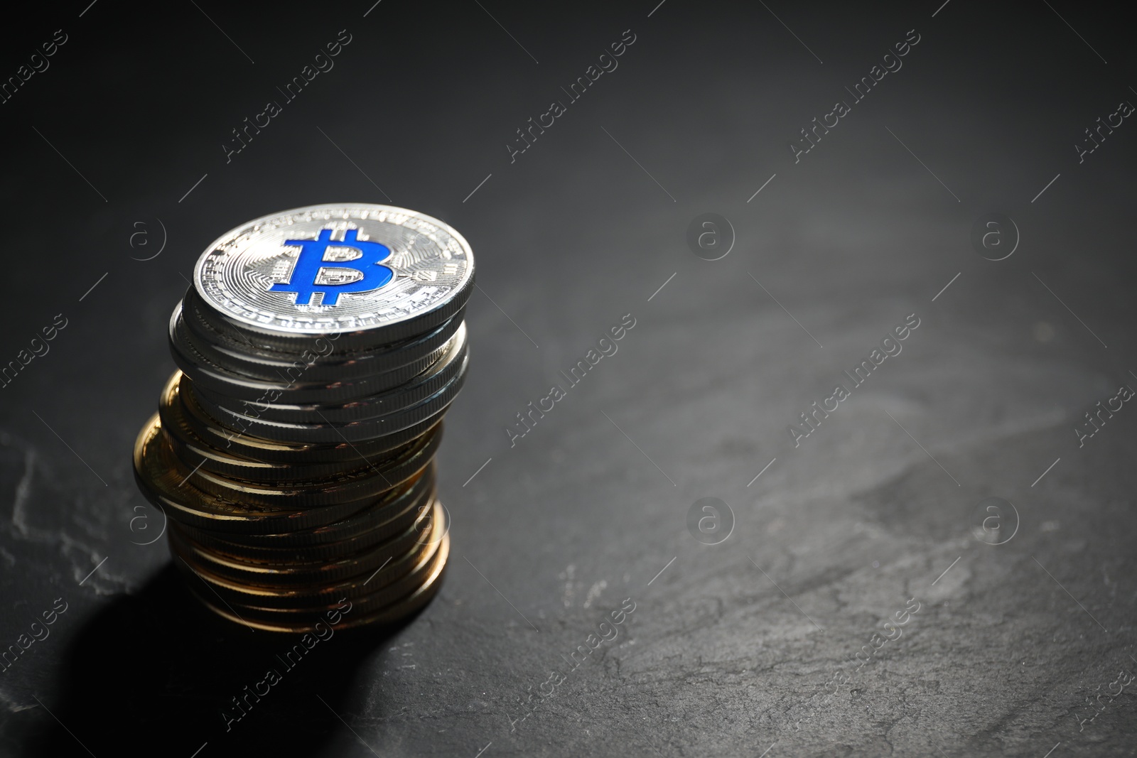 Cryptocurrency. Stack of bitcoins on black table, closeup. Space for text Photo of Cryptocurrency. Stack of bitcoins on black table, closeup. Space for text