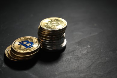 Photo of Cryptocurrency. Bitcoins on black table, closeup. Space for text