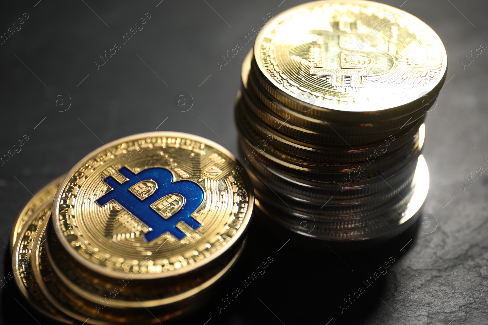Cryptocurrency. Bitcoins on black table, closeup view Photo of Cryptocurrency. Bitcoins on black table, closeup view