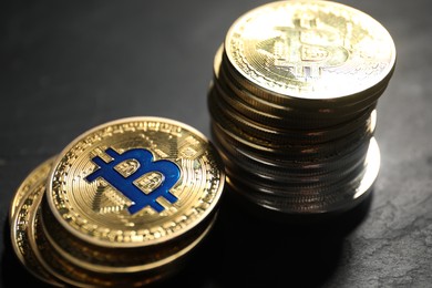 Photo of Cryptocurrency. Bitcoins on black table, closeup view