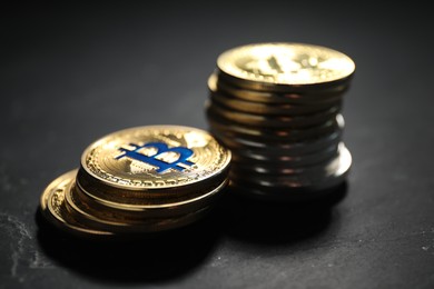 Photo of Cryptocurrency. Bitcoins on black table, closeup view