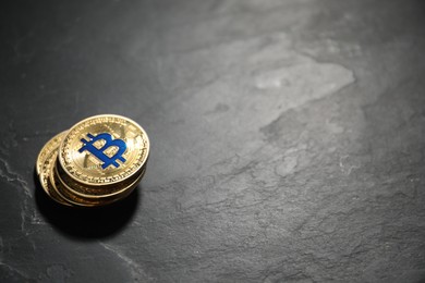 Photo of Cryptocurrency. Bitcoins on black table, closeup. Space for text