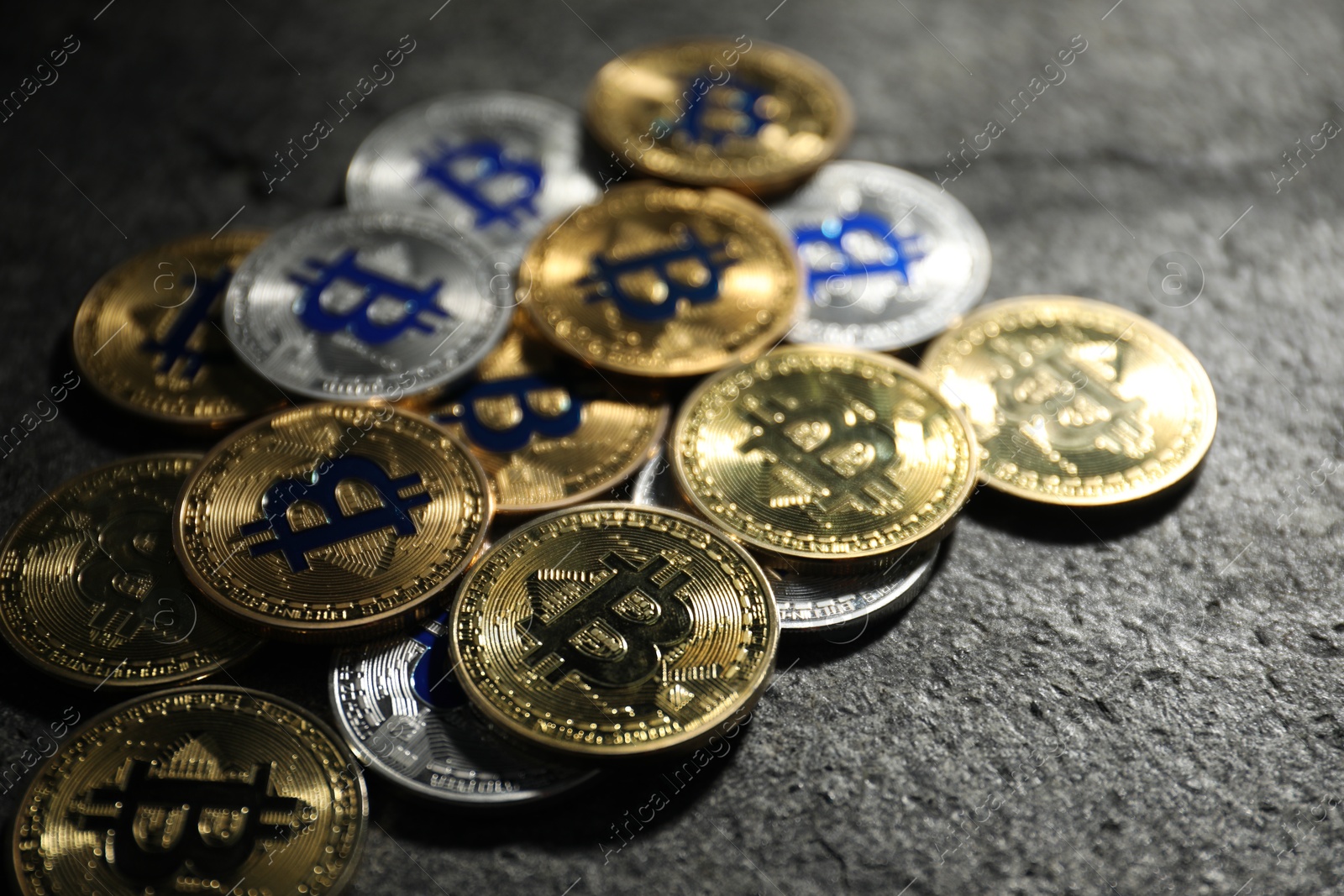 Cryptocurrency. Different bitcoins on grey table, closeup Photo of Cryptocurrency. Different bitcoins on grey table, closeup