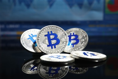 Photo of Cryptocurrency. Silver bitcoins on mirror surface, closeup