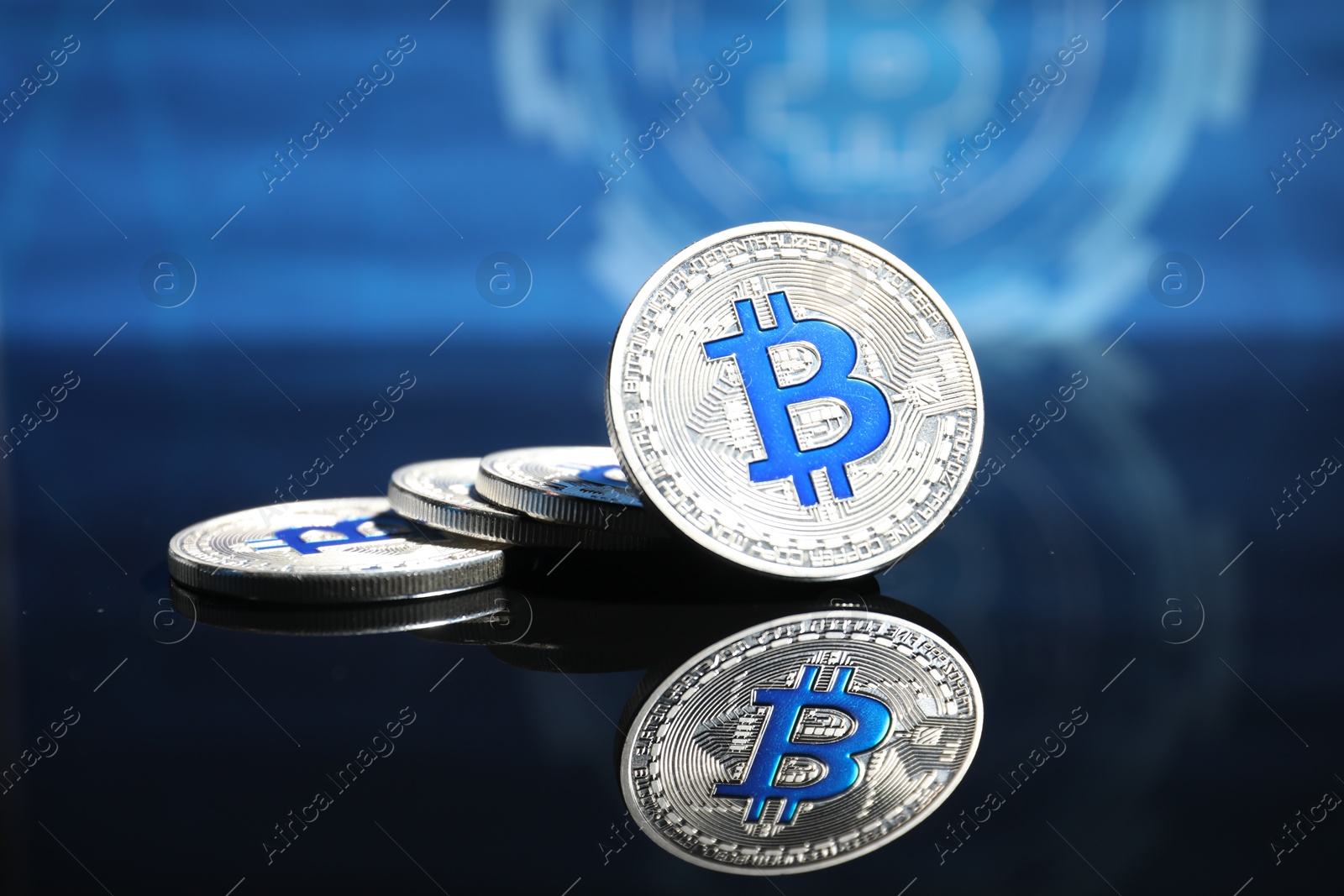 Cryptocurrency. Silver bitcoins on mirror surface, closeup Photo of Cryptocurrency. Silver bitcoins on mirror surface, closeup