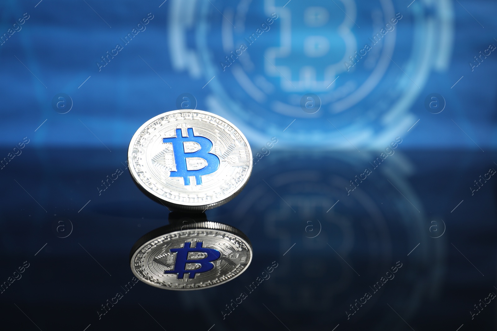 Cryptocurrency. One bitcoin on mirror surface, closeup. Space for text Photo of Cryptocurrency. One bitcoin on mirror surface, closeup. Space for text