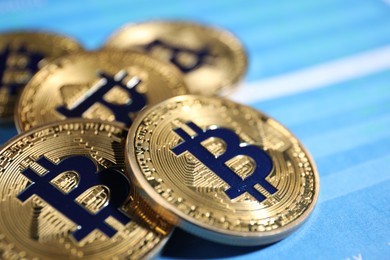 Photo of Cryptocurrency. Golden bitcoins on data charts, closeup
