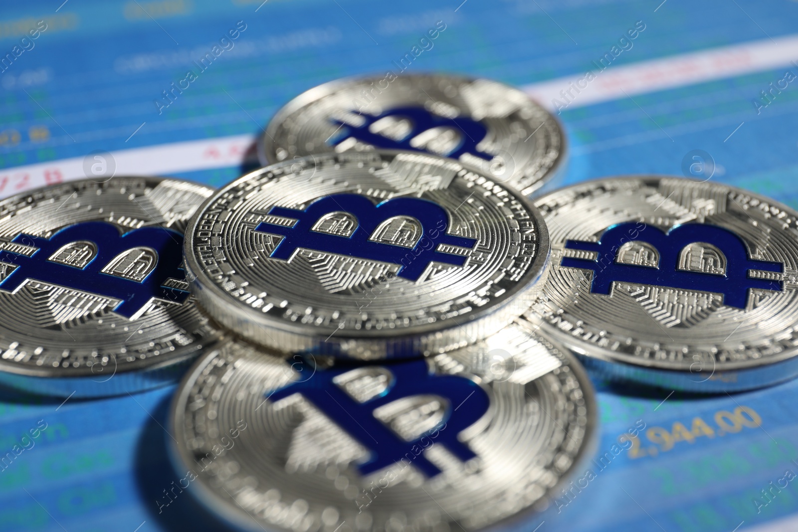 Cryptocurrency. Silver bitcoins on data charts, closeup Photo of Cryptocurrency. Silver bitcoins on data charts, closeup
