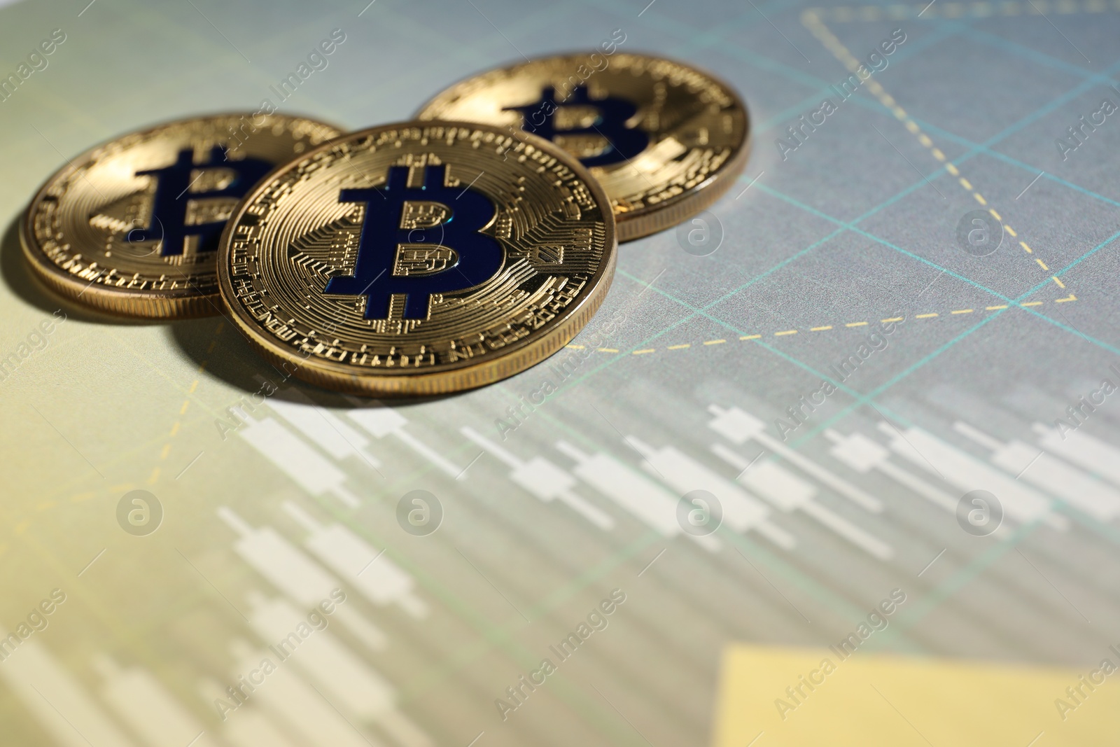 Cryptocurrency. Three bitcoins on data charts, closeup. Space for text Photo of Cryptocurrency. Three bitcoins on data charts, closeup. Space for text