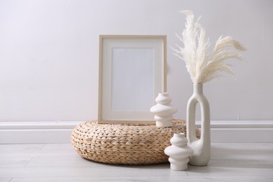 Photo of Empty picture frame and stylish home decor near white wall indoors