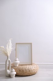 Photo of Empty picture frame and stylish home decor near white wall indoors