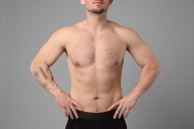 Photo of Young man with hairy chest on light grey background, closeup. Epilation procedure