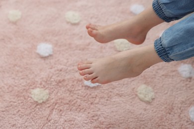 Photo of Girl above soft carpet at home, closeup
