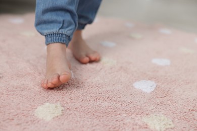 Photo of Girl walking on soft carpet at home, closeup. Space for text