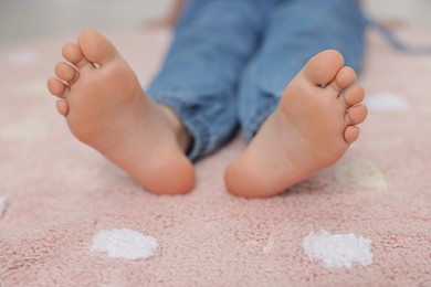 Photo of Girl on soft carpet at home, closeup