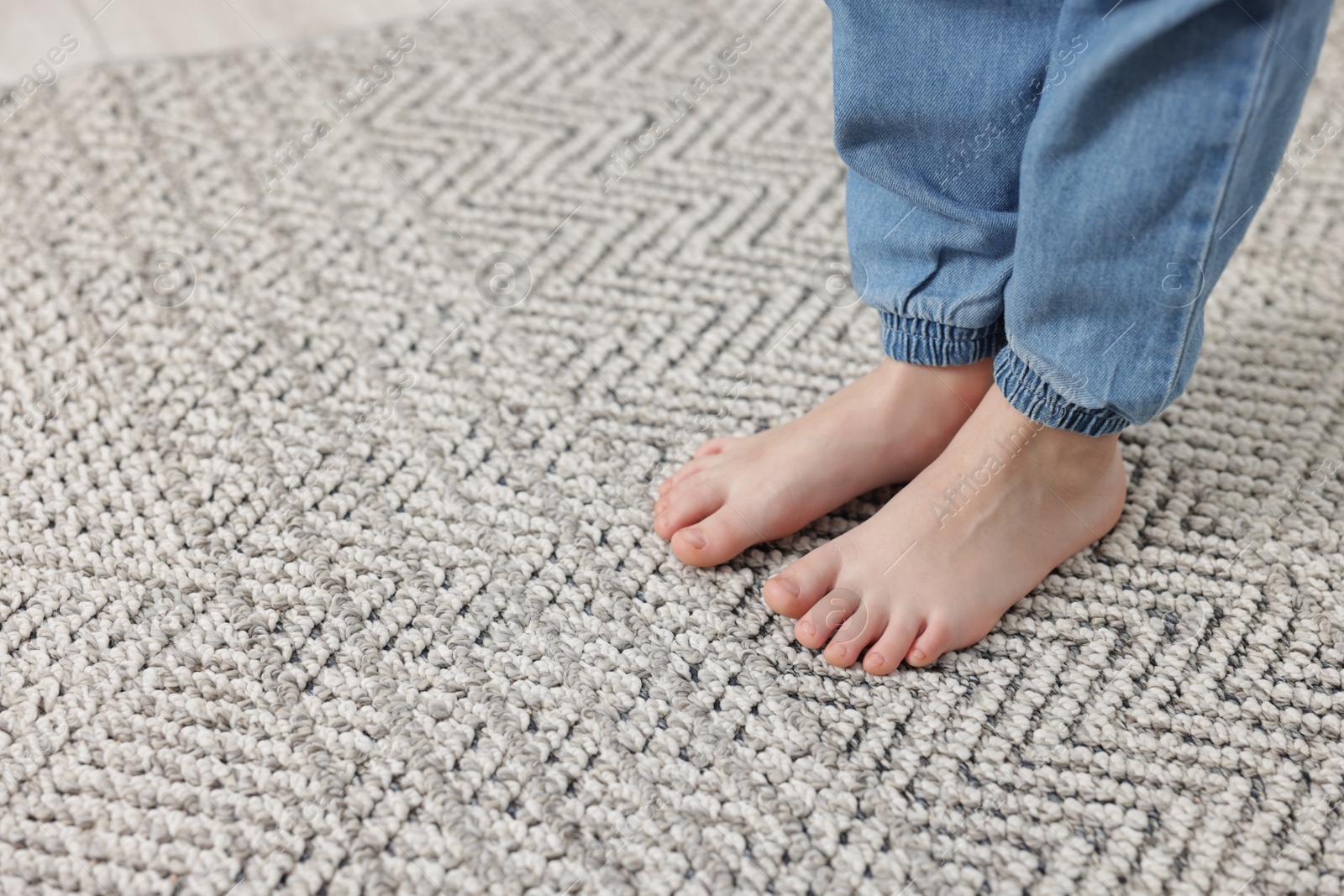 Girl on grey carpet at home, closeup. Space for text Photo of Girl on grey carpet at home, closeup. Space for text