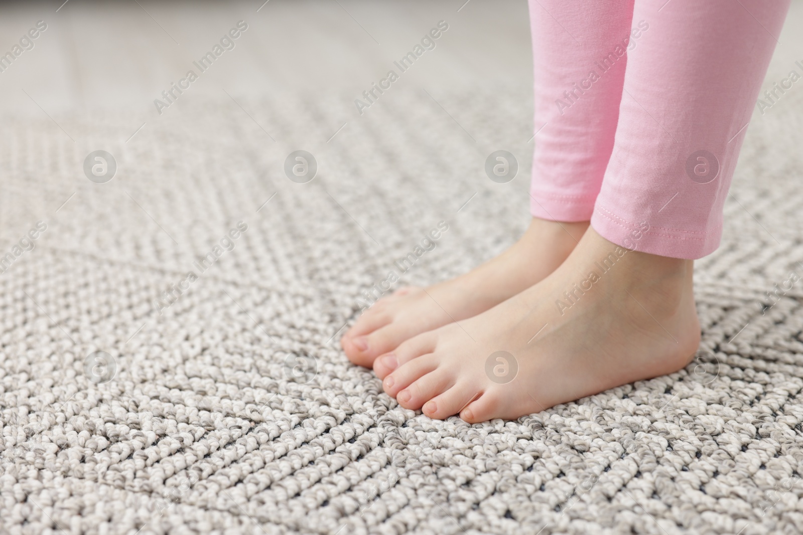 Girl on grey carpet at home, closeup. Space for text Photo of Girl on grey carpet at home, closeup. Space for text