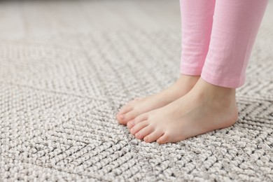Photo of Girl on grey carpet at home, closeup. Space for text