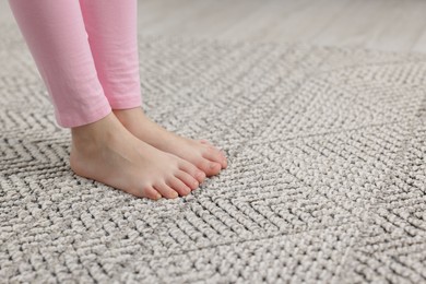 Photo of Girl on grey carpet at home, closeup. Space for text