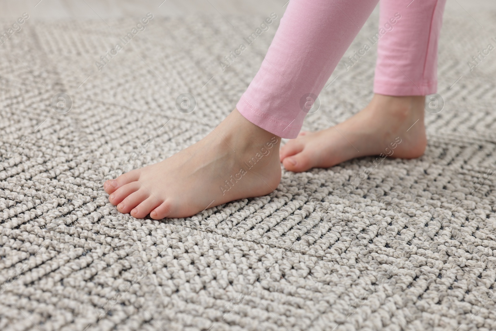 Girl walking on grey carpet at home, closeup Photo of Girl walking on grey carpet at home, closeup