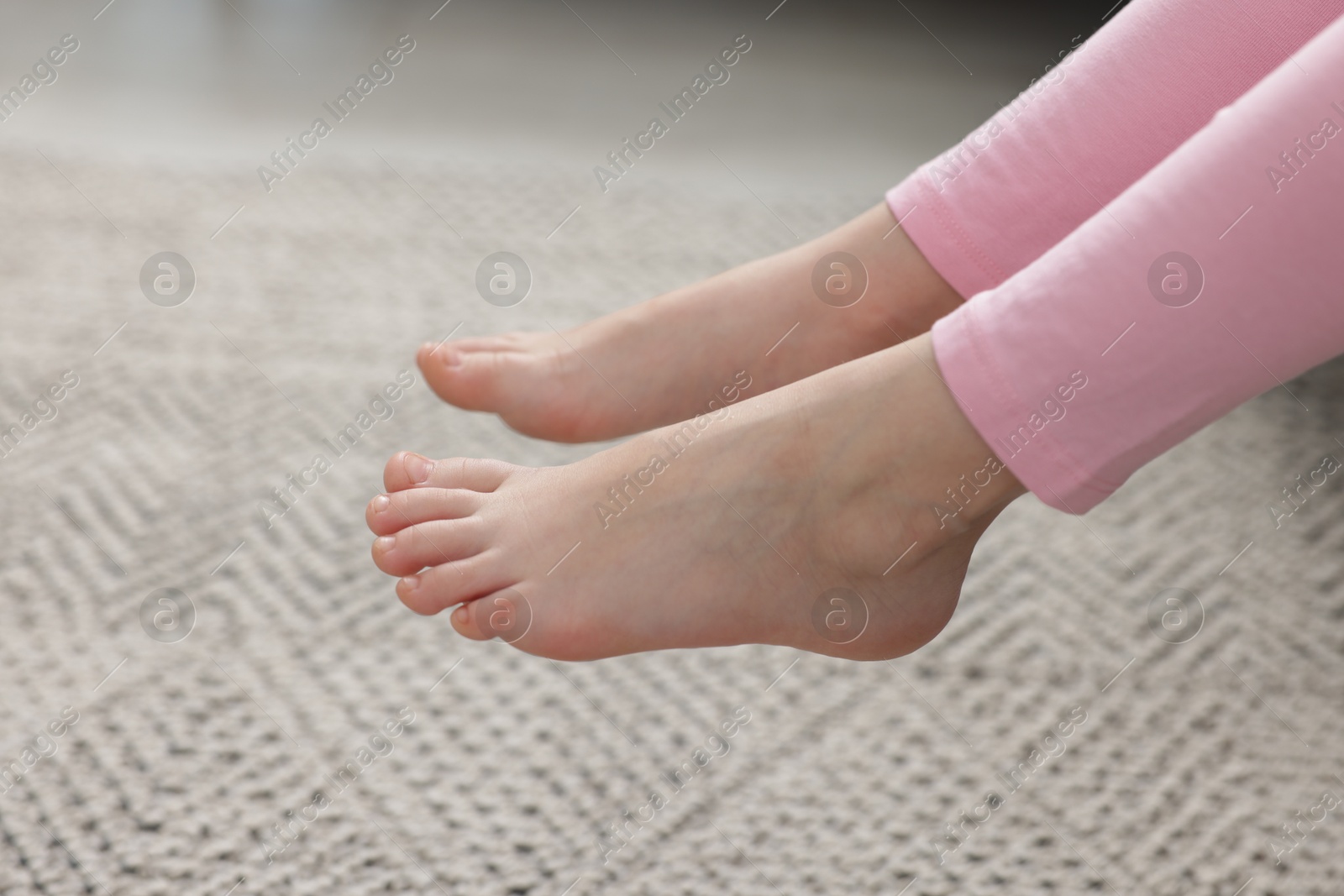Girl above grey carpet at home, closeup Photo of Girl above grey carpet at home, closeup