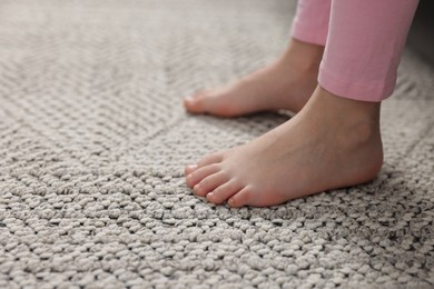 Photo of Girl on grey carpet at home, closeup