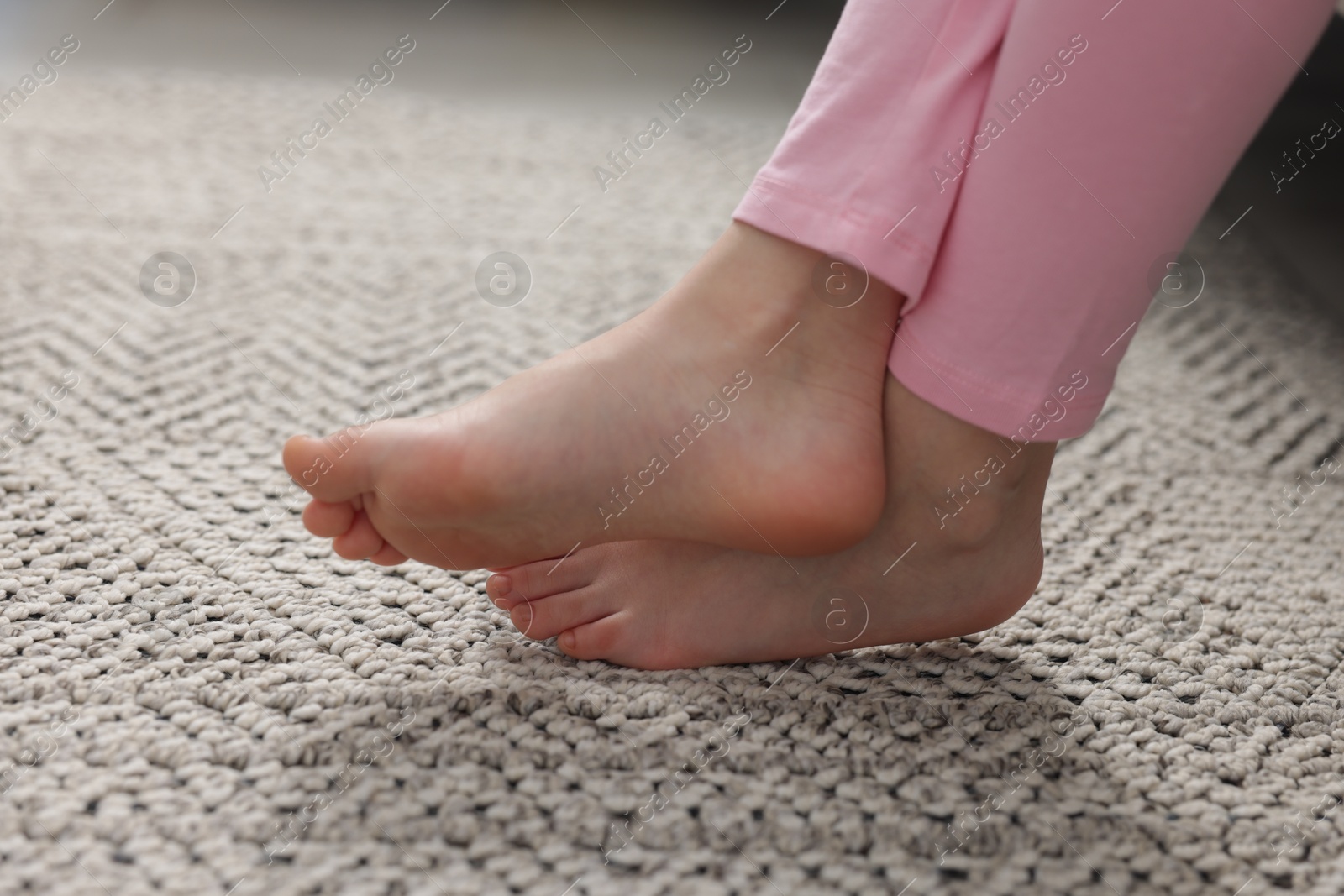 Girl on grey carpet at home, closeup Photo of Girl on grey carpet at home, closeup