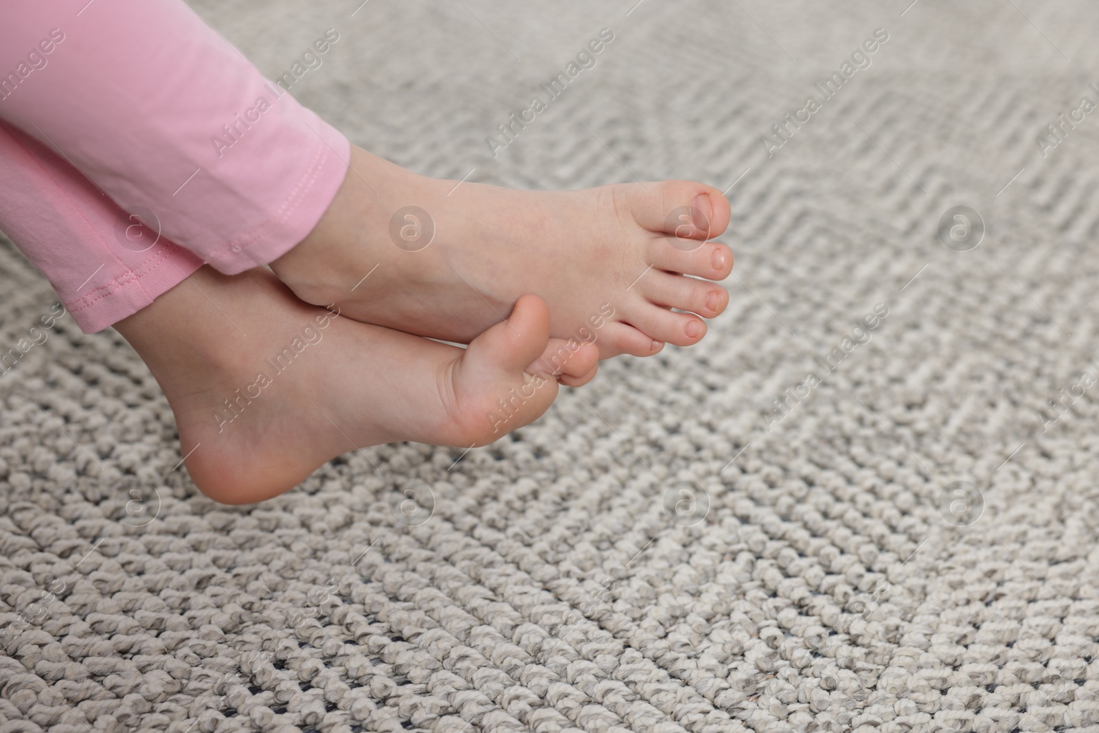 Girl on grey carpet at home, closeup Photo of Girl on grey carpet at home, closeup