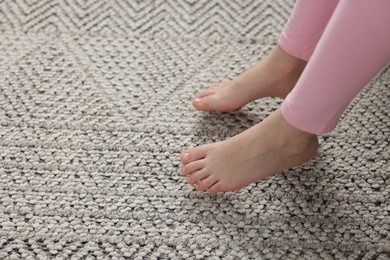 Photo of Girl above grey carpet at home, closeup
