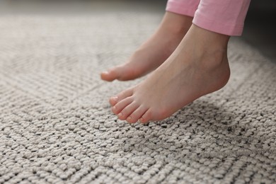 Photo of Girl above grey carpet at home, closeup